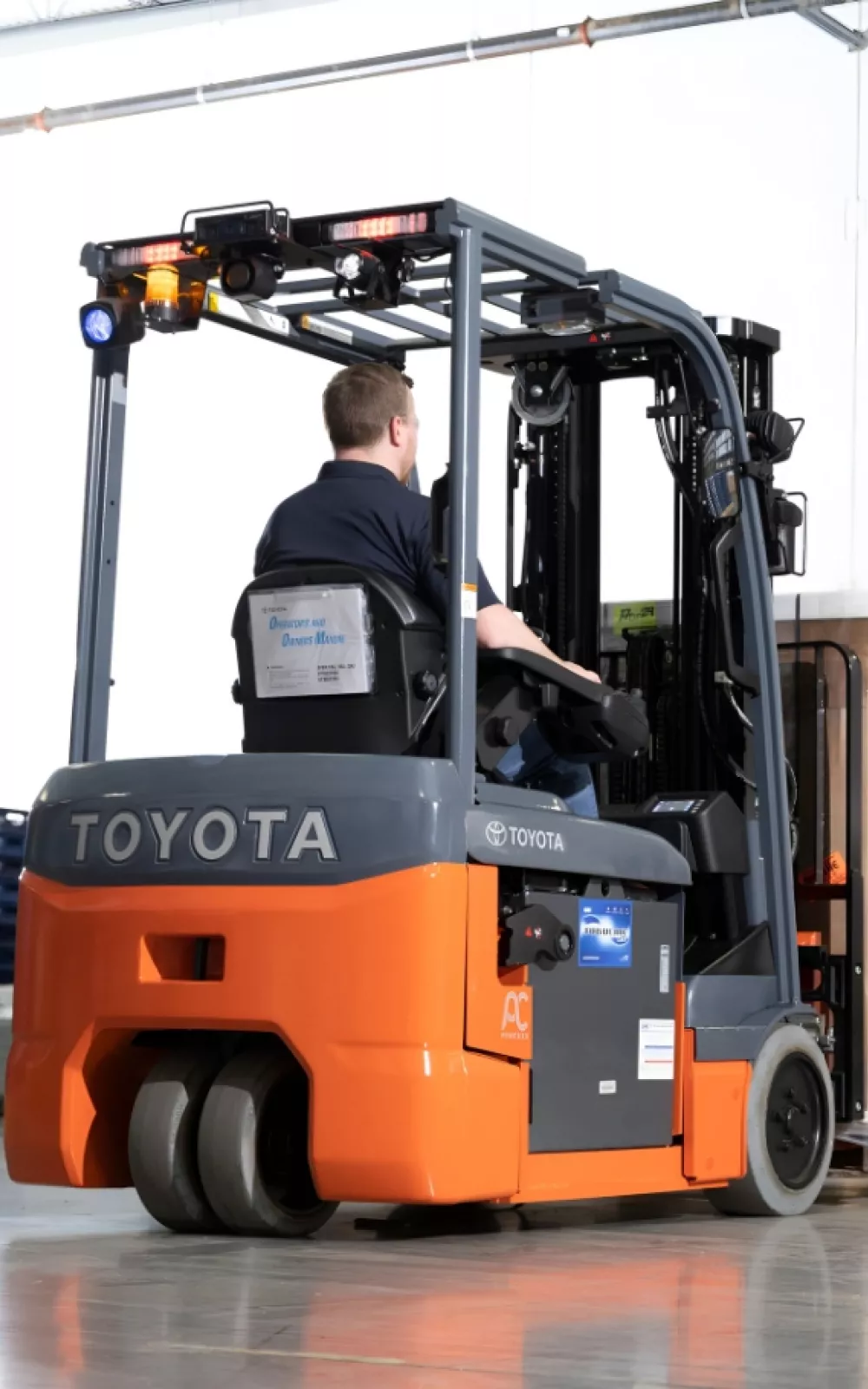 Forklift operator picking up product with a Toyota 3-Wheel electric forklift.
