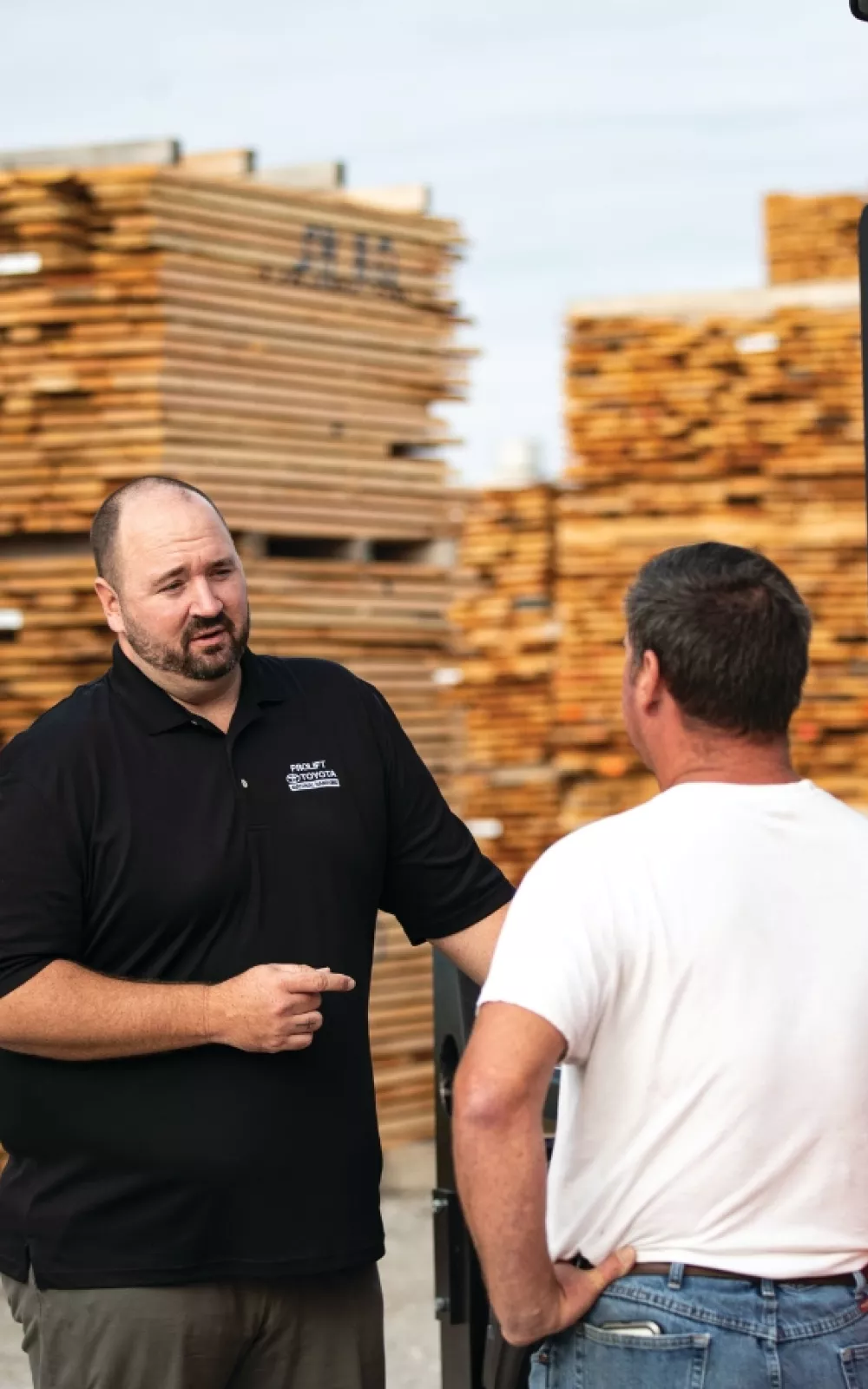 Sales consultant and customer discussing forklift maintenance programs.