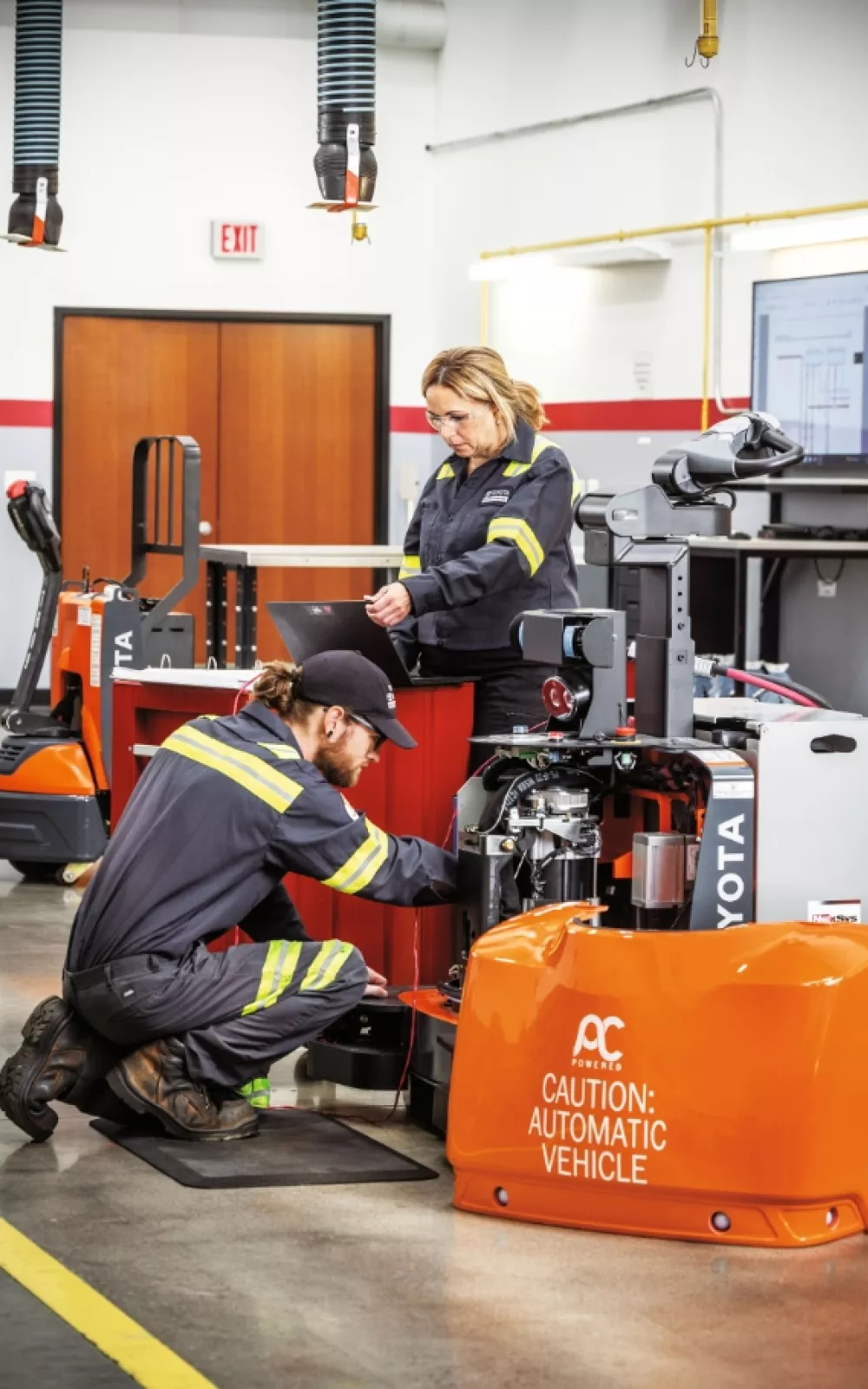 Toyota service technicians performing service on automated guided vehile and AGV parts.
