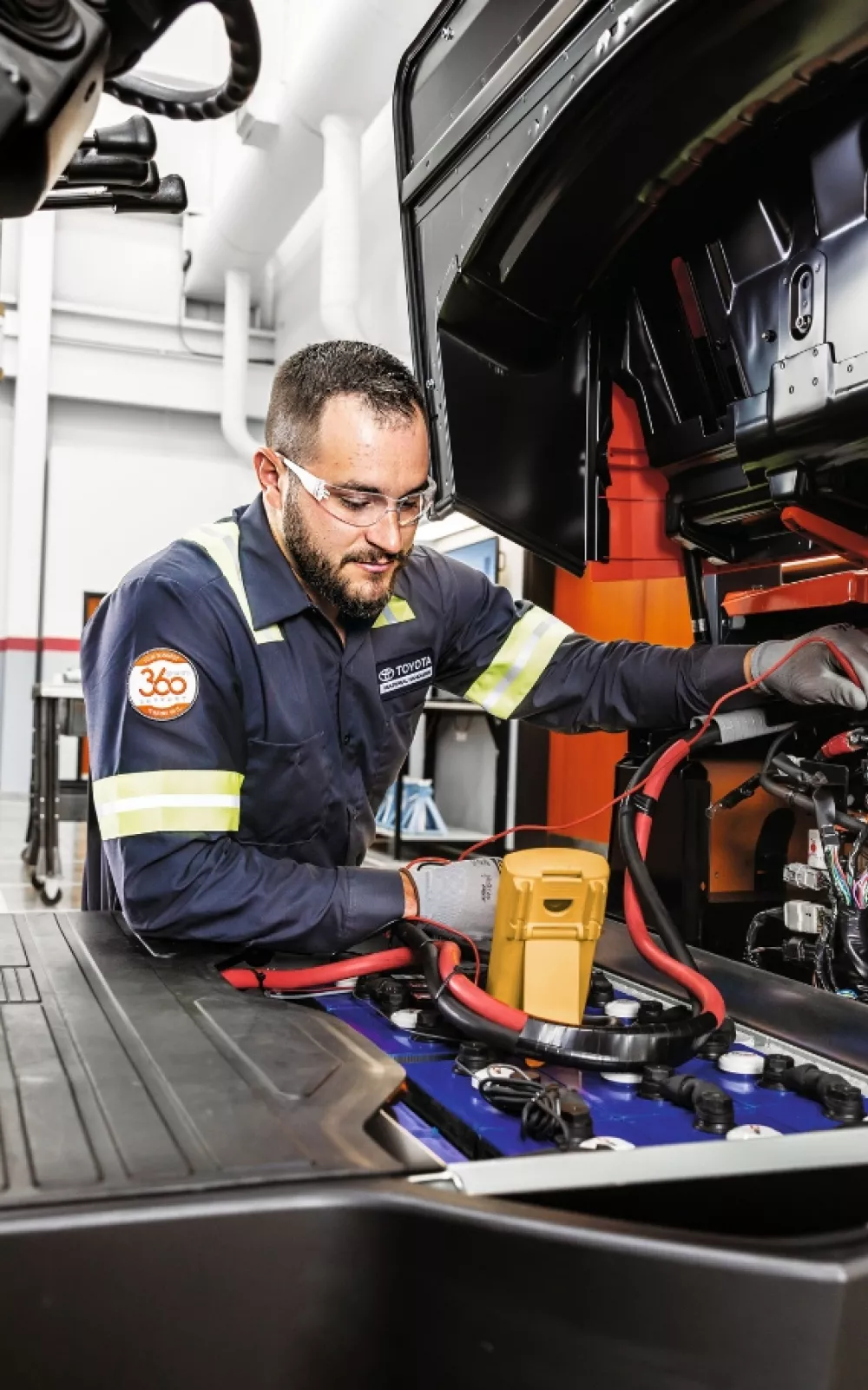 Toyota service technician performing forklift maintenance.