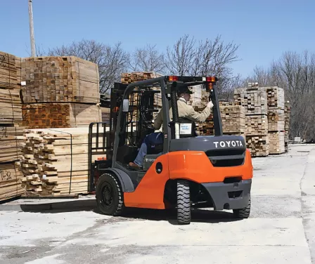Toyota mid IC pneumatic forklift rental moving lumber in an outdoor application.