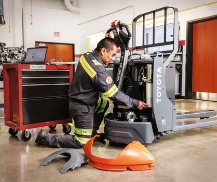 Toyota service technician performing forklift service.