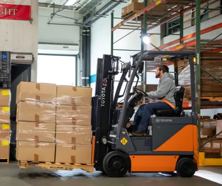 Toyota electric forklift moving boxes on a pallet. 