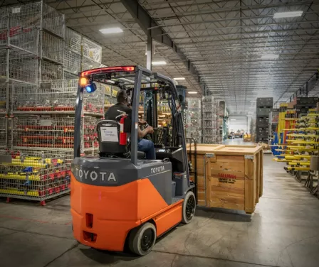 Toyota electric forklift moving boxes on a pallet. 
