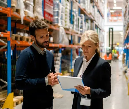 ProLift Toyota sales consultants reviewing a customer proposal in a warehouse.