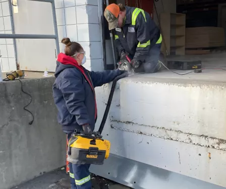 Dock and door service technicians performing maintenance on loading dock equipment.