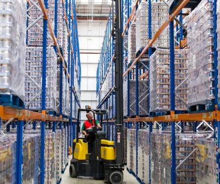 Aisle Master very narrow aisle forklift rental unloaded product from pallet racking.