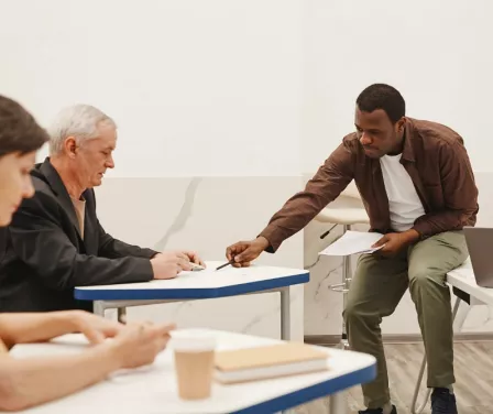 Forklift trainer discussing an exam with operator during safety training class.
