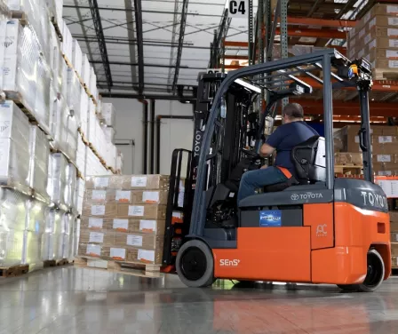 Toyota 3-wheel electric forklift moving product in cold storage industry.
