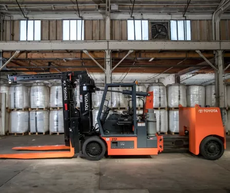 Toyota large capacity adjustable wheelbase forklift in a warehouse.