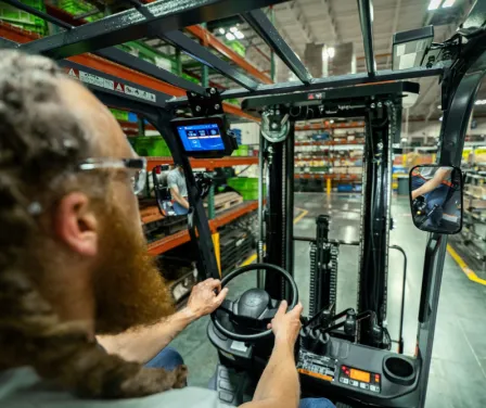 Forklift operator driving Toyota forklift with MyInsights Telematics.
