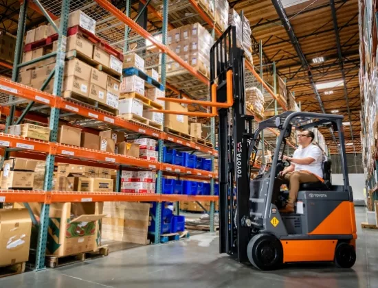 Toyota electric forklift lifting forks to unload product from pallet racking.