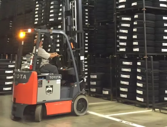 Toyota core electric forklift carrying black tires.