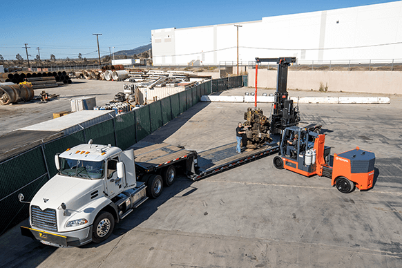 high capacity adjustable wheelbase forklift loading a semi truck