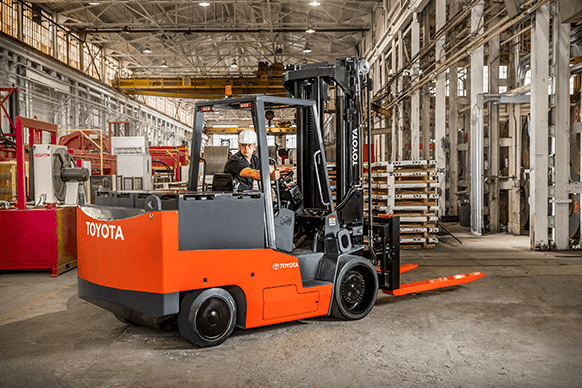 ProLift Toyota employee uses an orange and gray high capacity electric forklift