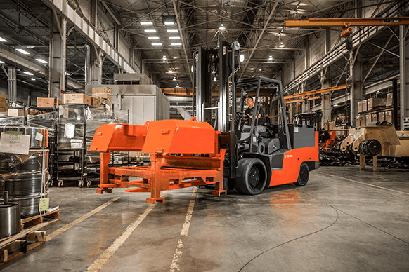 High-capacity electric forklift lifting heavy machinery