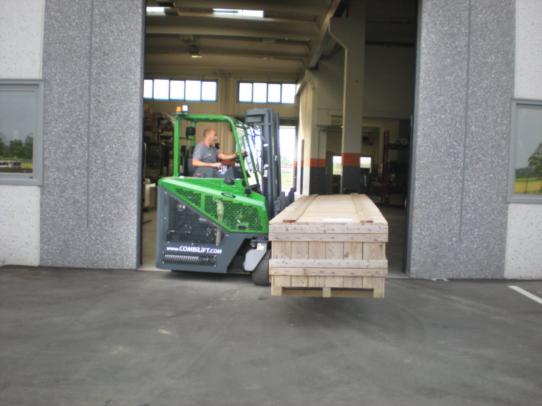 a warehouse worker moves materials with a combilift forklift
